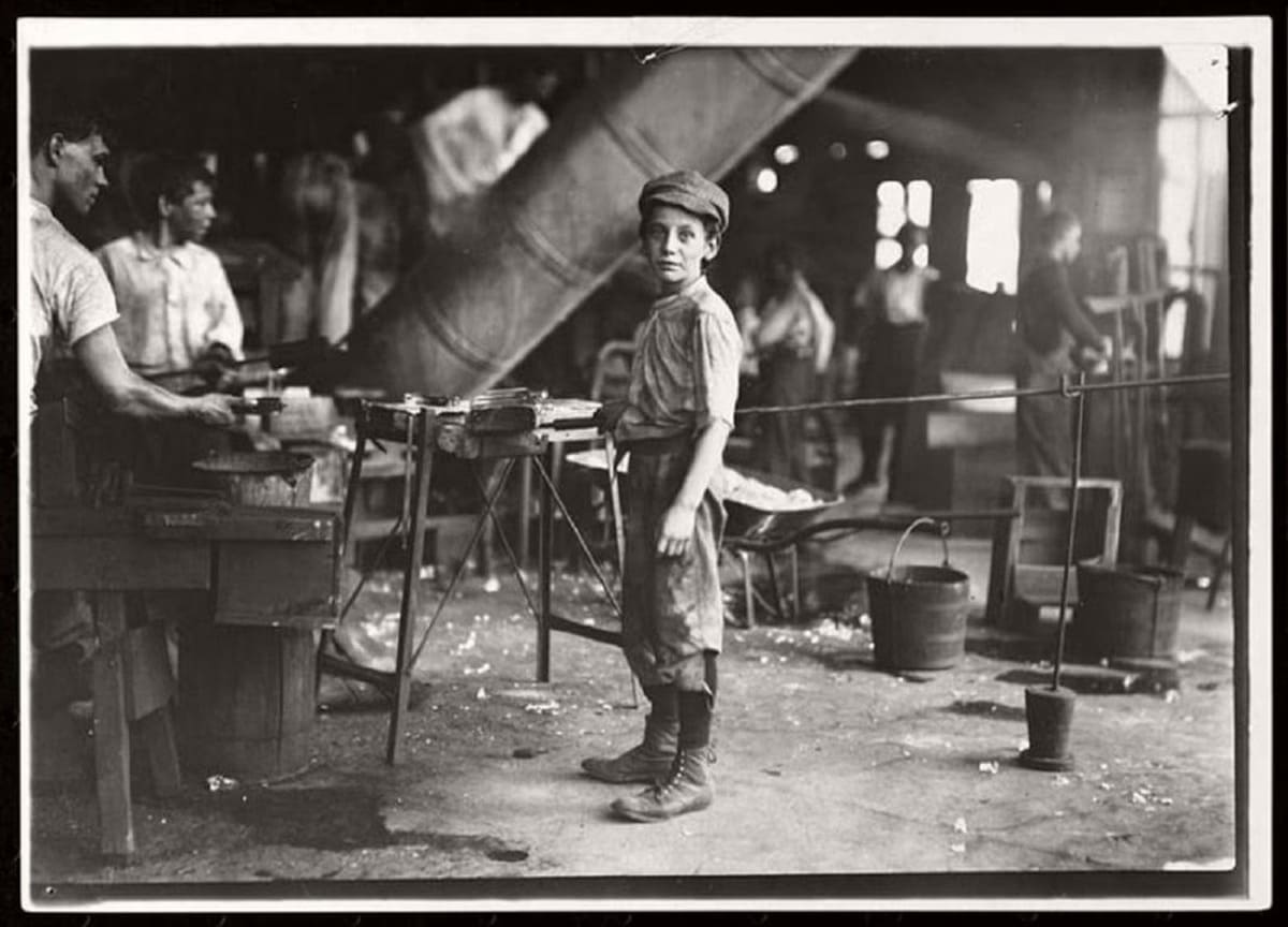 Fotografia de um rapaz a trabalhar numa fábrica, por Jacob Riis, finais do século XIX.